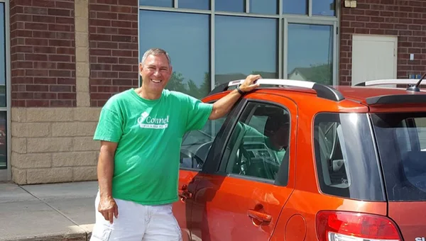 An O'Connell Pharmacy delivery driver standing beside the delivery van